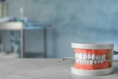 Photo of Educational model of oral cavity and dentist mirror on table indoors. Space for text