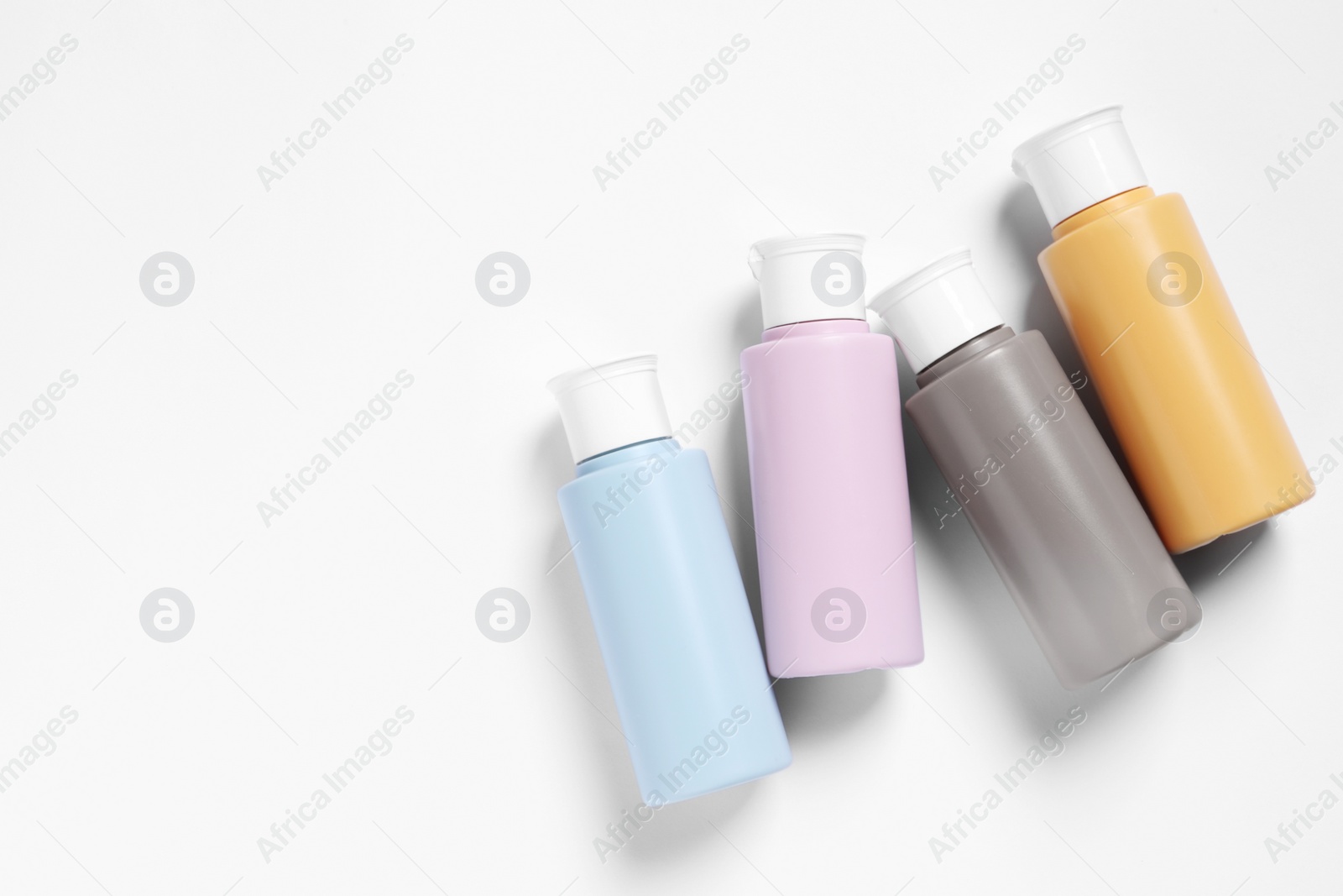 Photo of Cosmetic travel kit on white background, flat lay. Space for text