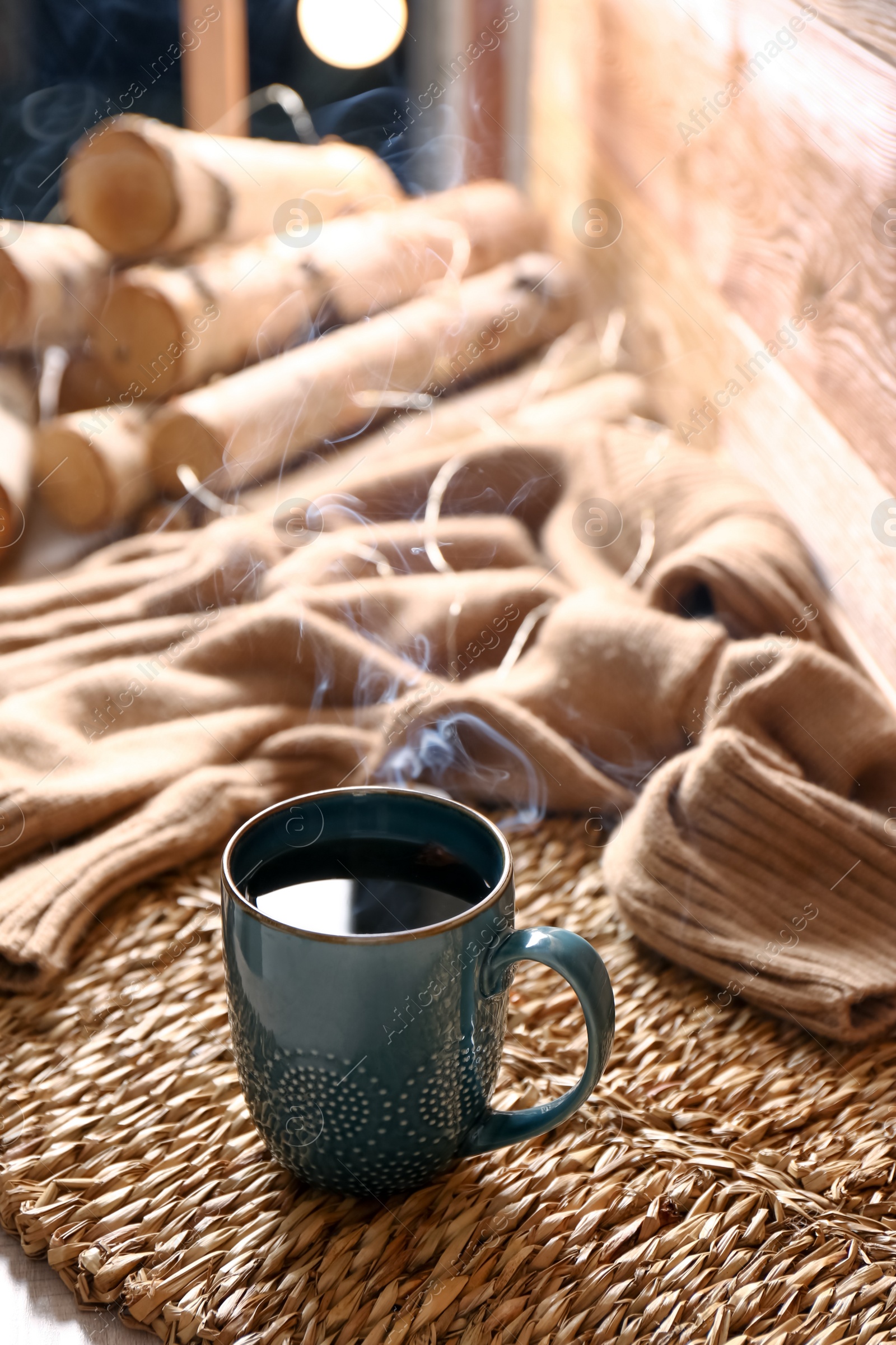 Photo of Wicker mat with freshly brewed tea in room. Cozy home atmosphere