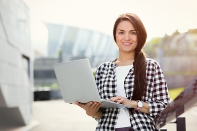 Photo of Beautiful woman with laptop outdoors on sunny day
