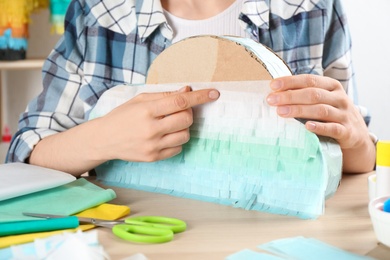 Woman decorating cardboard cloud at table, closeup. Pinata diy