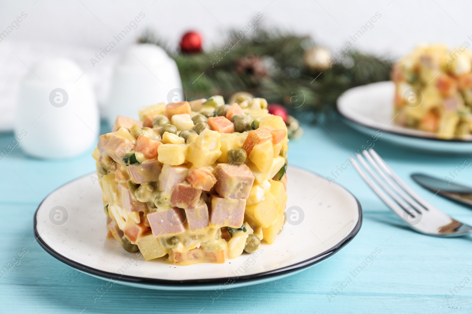 Photo of Traditional russian salad Olivier served on turquoise wooden table, closeup