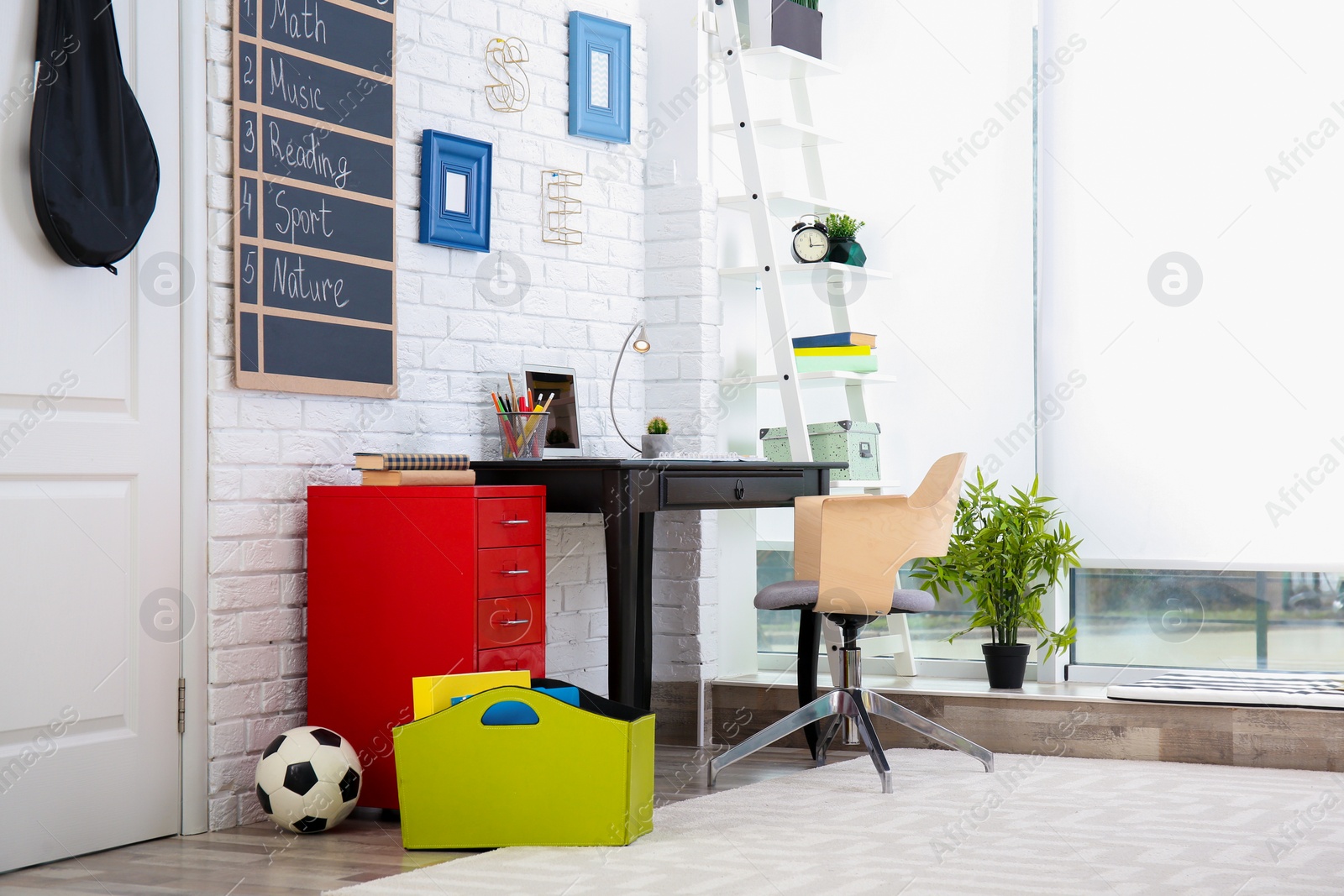 Photo of Modern child room interior with desk and laptop