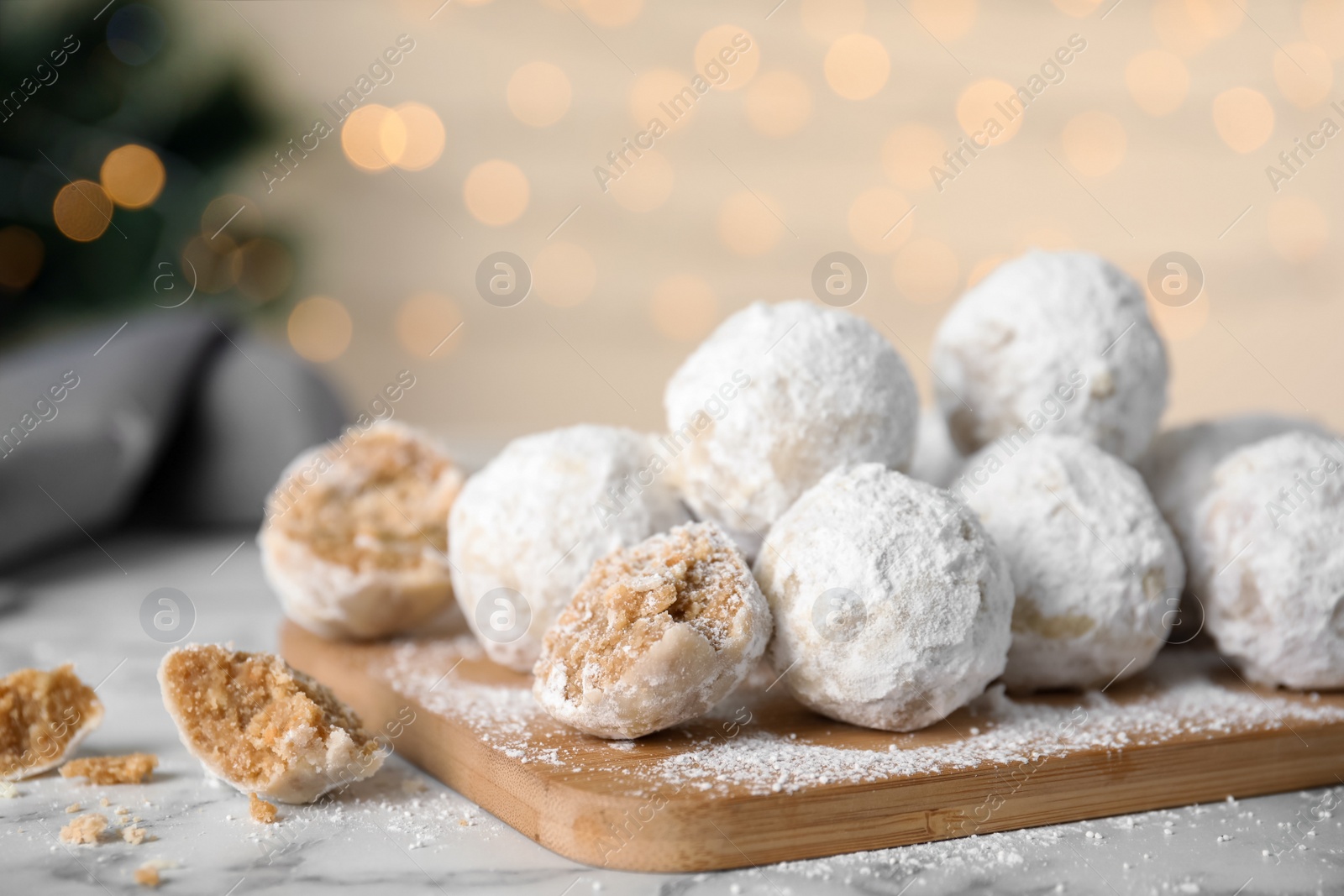 Photo of Tasty snowball cookies on wooden board, closeup. Christmas treat