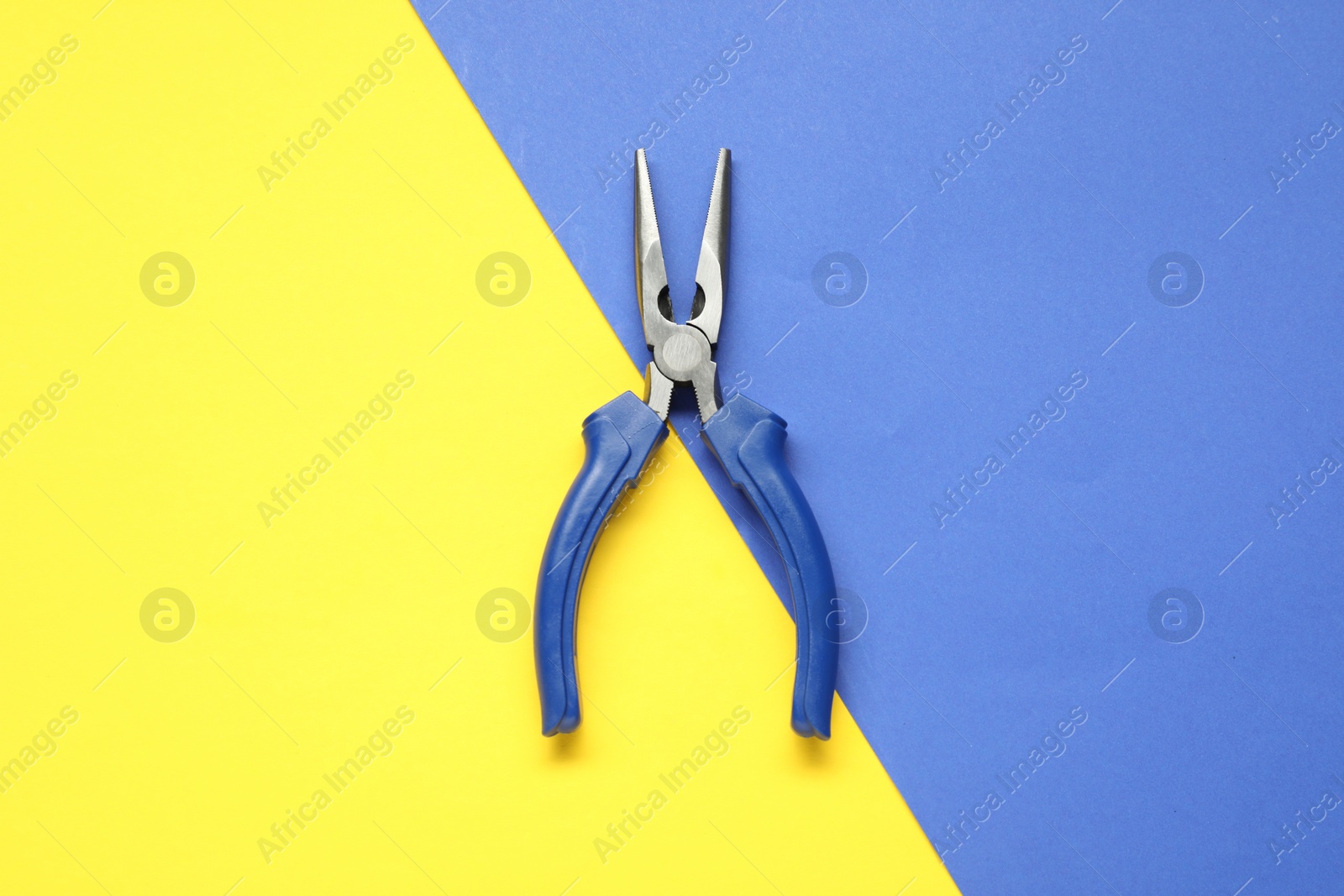 Photo of Needle nose pliers on color background, top view