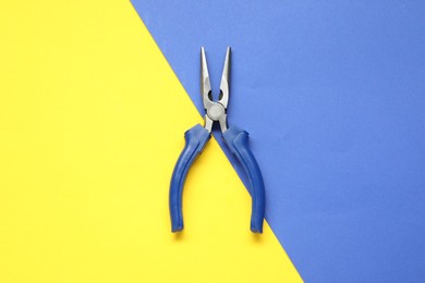 Needle nose pliers on color background, top view