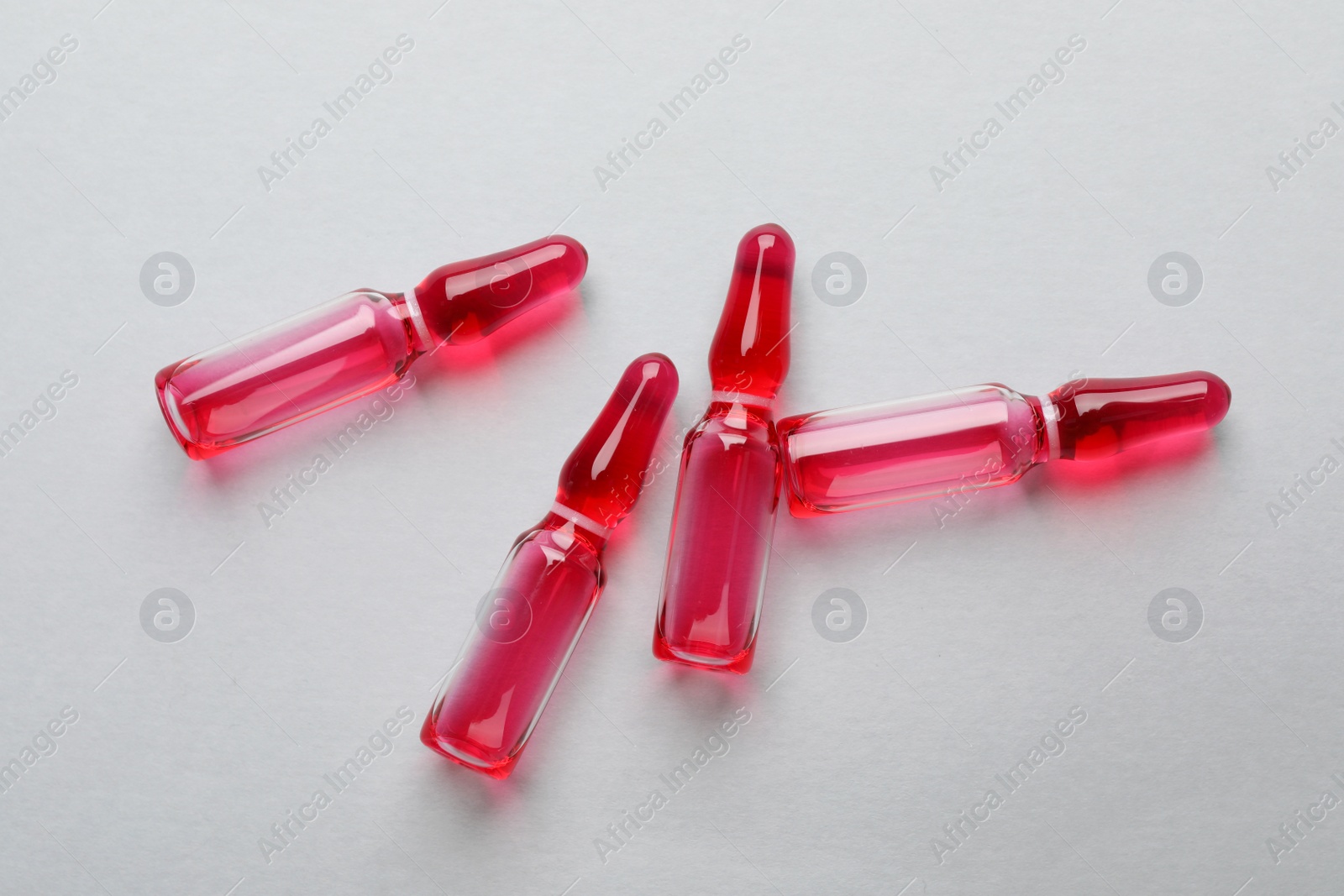 Photo of Pharmaceutical ampoules with medication on white background, flat lay