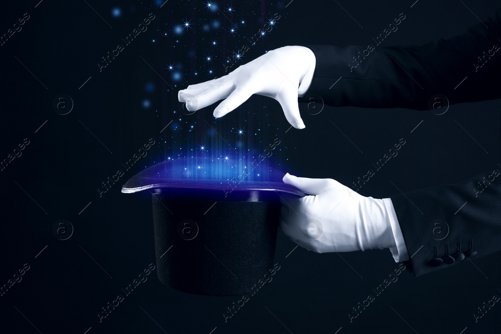 Image of Magician showing trick with top hat on black background, closeup