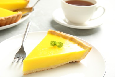 Photo of Slice of delicious homemade lemon pie on grey table