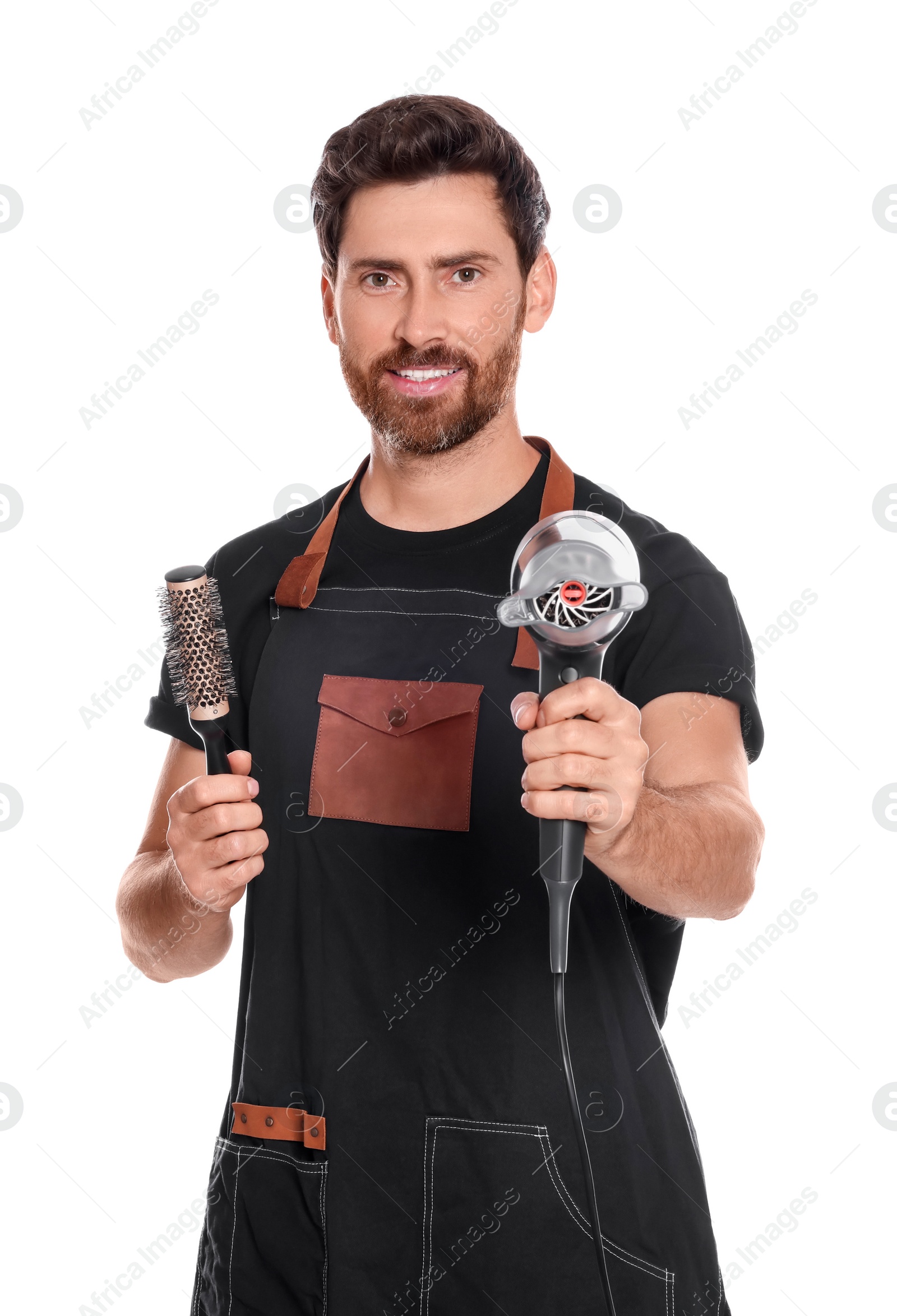 Photo of Professional hairdresser holding brush and dryer on white background