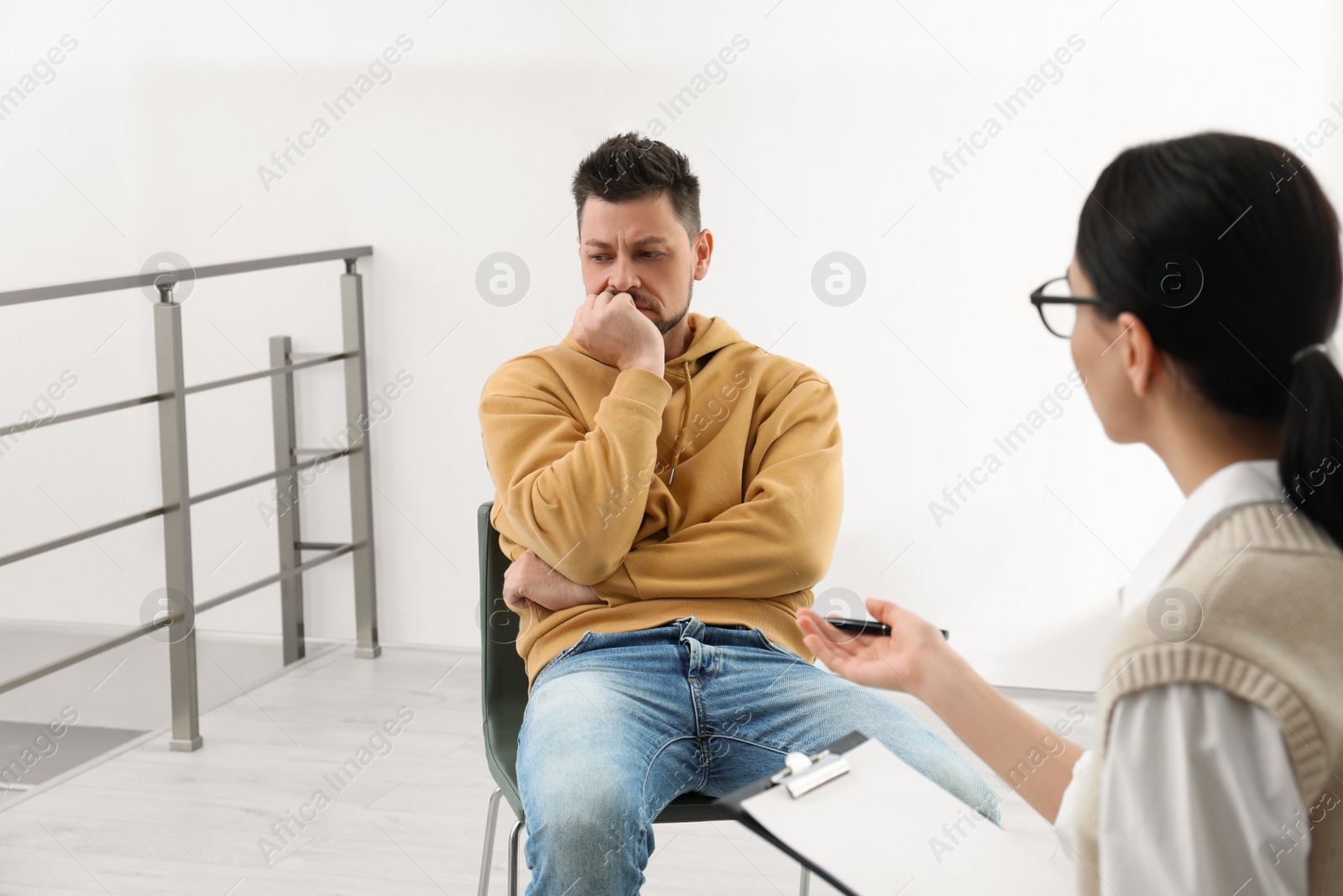 Photo of Psychotherapist working with drug addicted man indoors