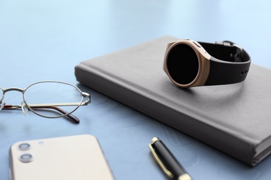 Photo of Composition with stylish smart watch on grey stone table