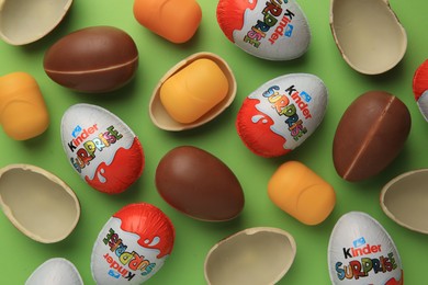 Photo of Sveti Vlas, Bulgaria - June 29, 2023: Kinder Surprise Eggs and plastic capsules on light green background, flat lay