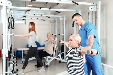 Patient exercising under physiotherapist supervision in rehabilitation center