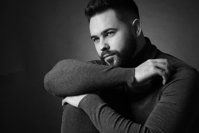 Portrait of handsome bearded man on dark background. Black and white effect