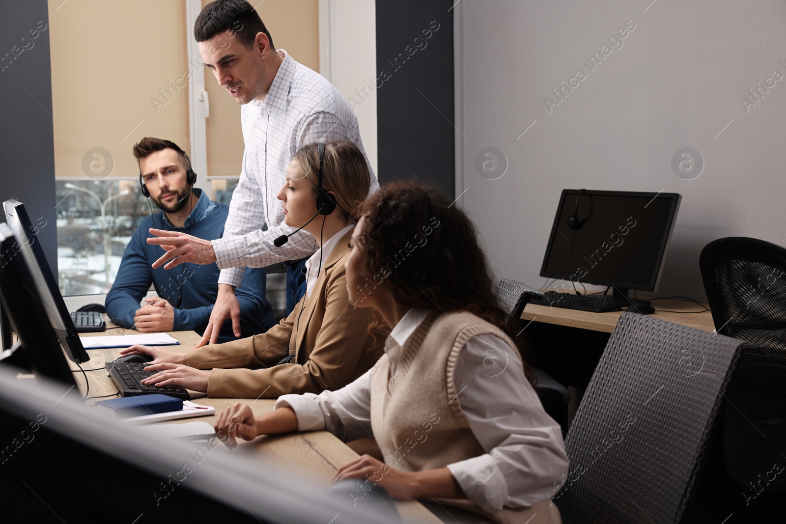 Photo of Call center operators working in modern office