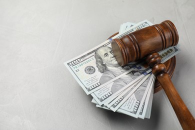 Photo of Judge's gavel and money on grey table. Space for text