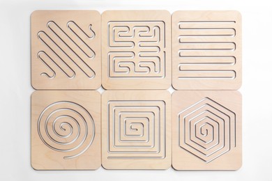 Wooden finger labyrinths on white background, top view. Montessori toy
