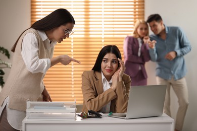 Woman scolding employee at workplace in office