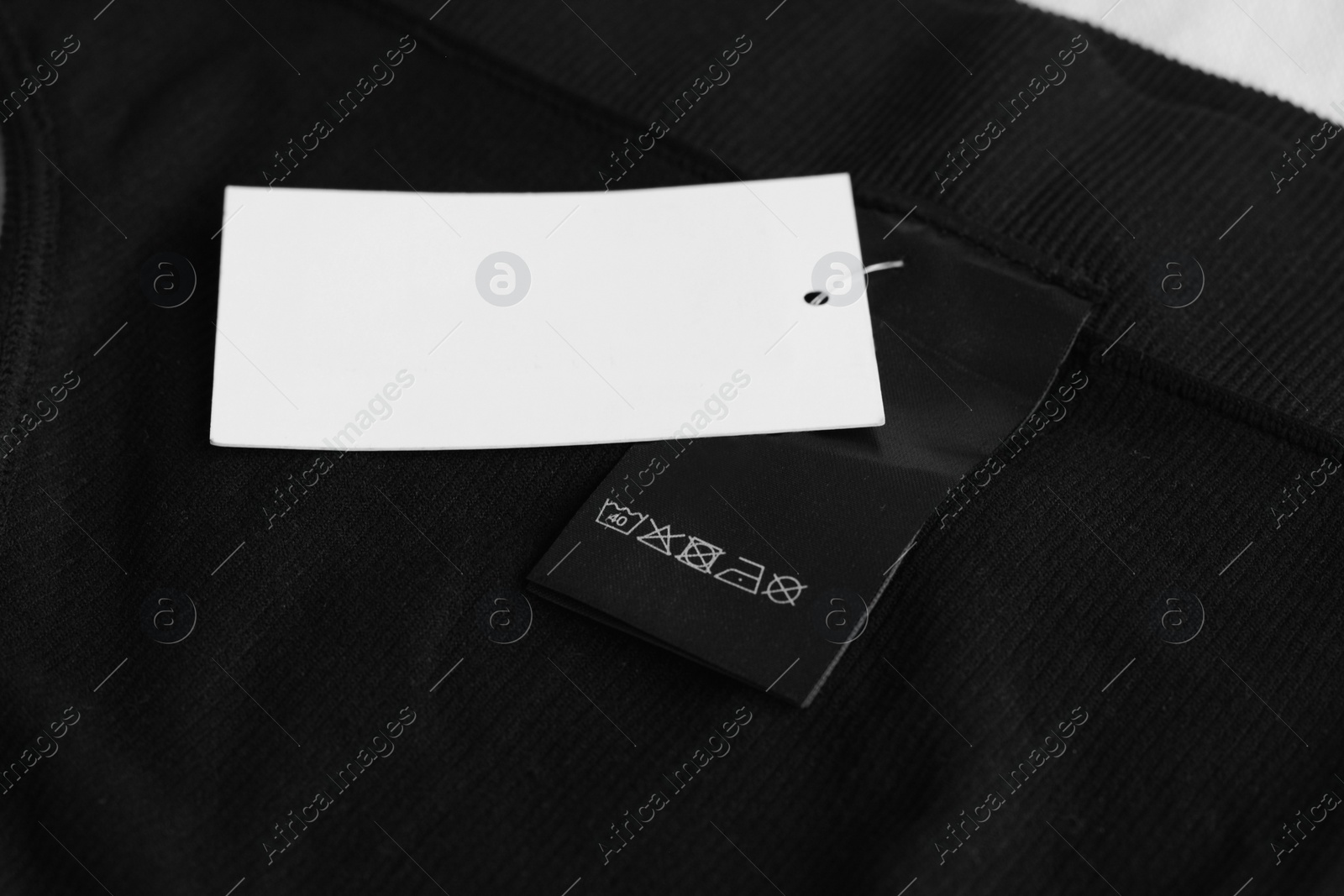 Photo of Clothing label with care information and tag on black garment