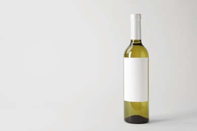 Photo of Bottle of delicious wine with blank label on white background