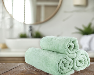 Image of Fresh towels on wooden table in bathroom