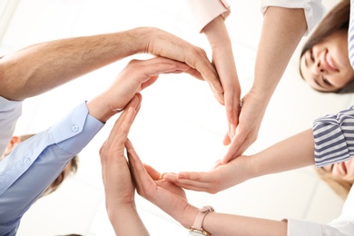People putting their hands in circle on light background. Unity concept