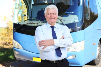 Photo of Professional driver standing near bus. Passenger transportation