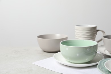 Photo of Beautiful ceramic dishware and cup on light grey table, space for text