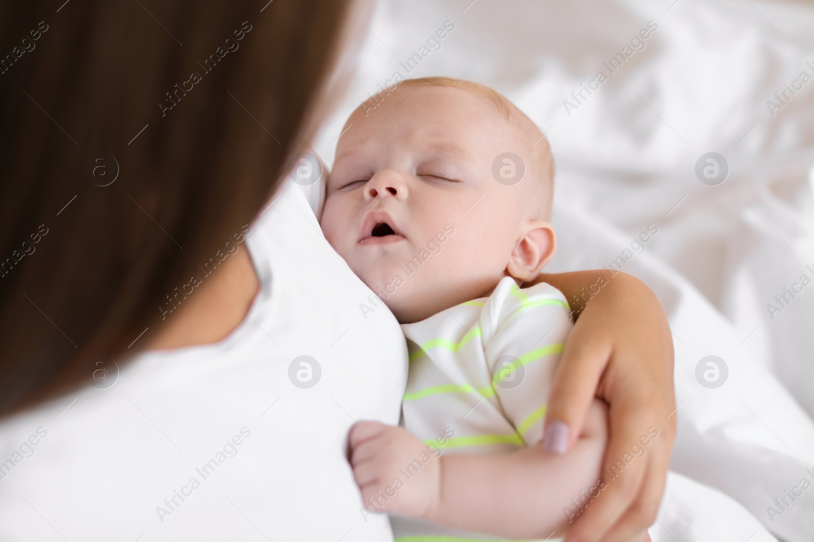 Photo of Mother with her sleeping baby at home, closeup view