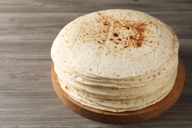 Many tasty homemade tortillas on wooden table