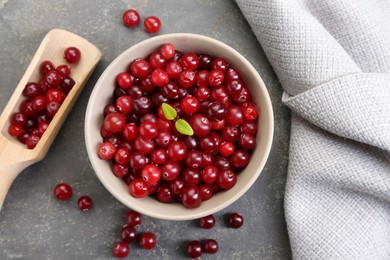 Photo of Fresh ripe cranberries in bowl and scoop on grey table, flat lay