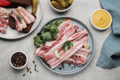 Photo of Flat lay composition of tasty pork fatback and spices on grey table