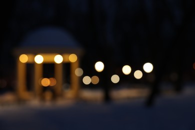Photo of Gazebo and snow in evening park, blurred view