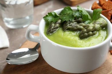 Photo of Delicious asparagus soup served on table, closeup