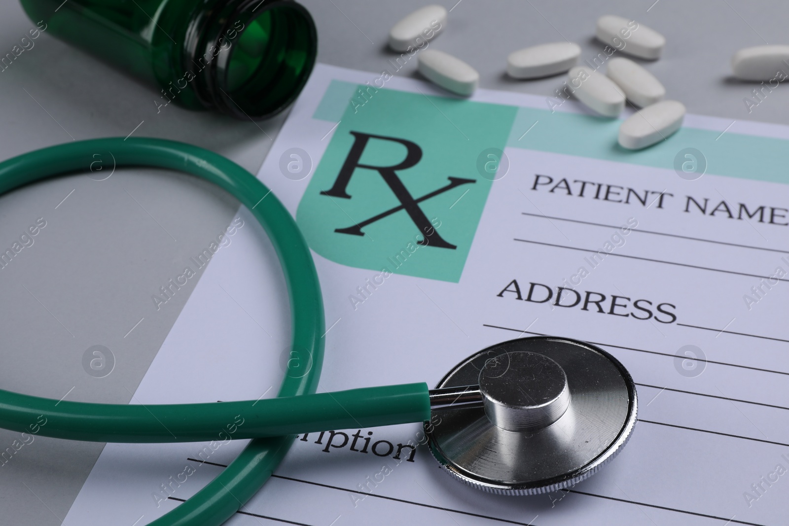 Photo of Medical prescription form, stethoscope and pills on light grey background, closeup