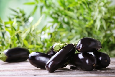 Photo of Ripe eggplants on table against blurred background