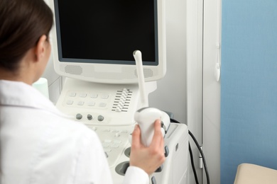 Professional sonographer using modern ultrasound machine in clinic