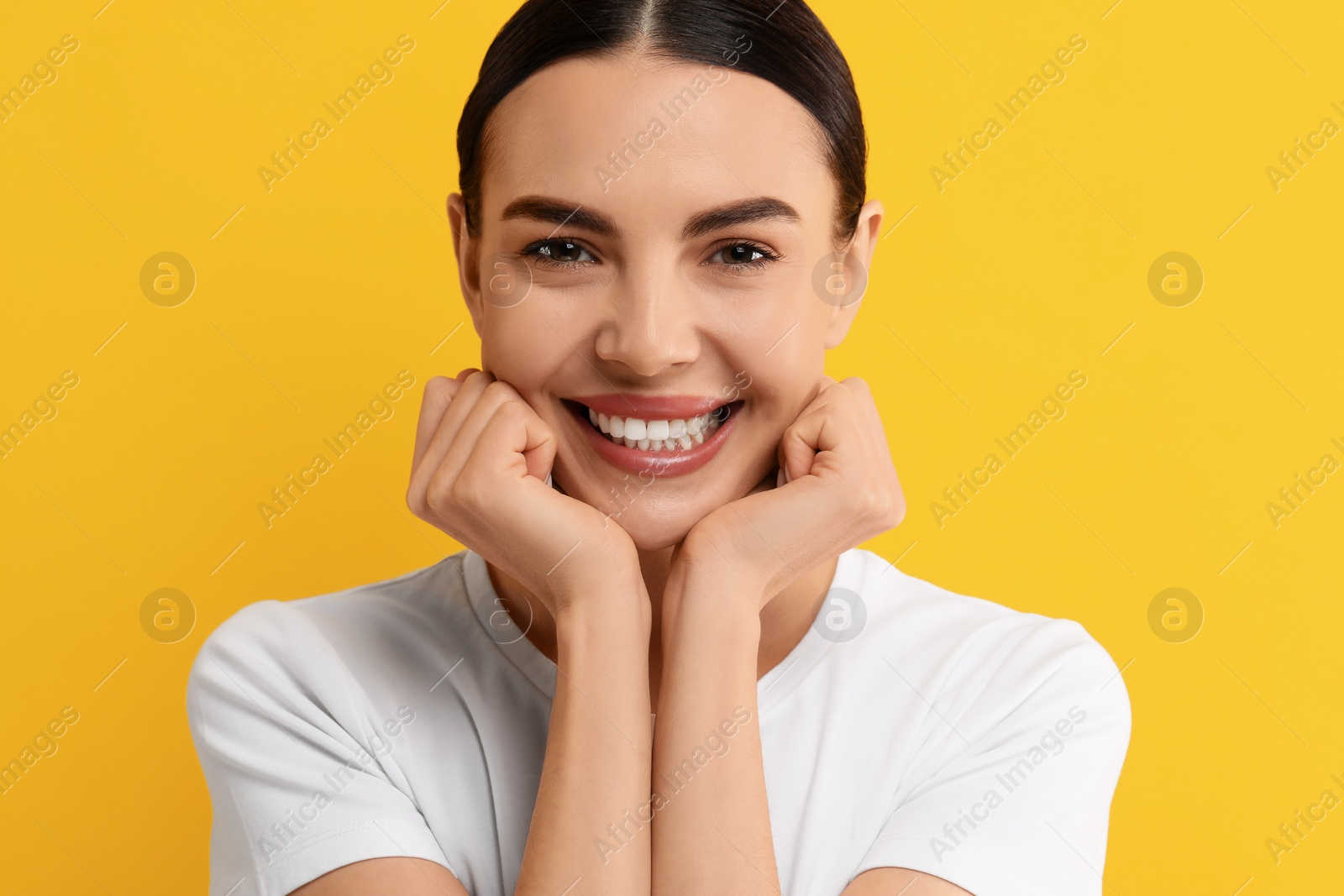 Photo of Beautiful woman with clean teeth smiling on yellow background