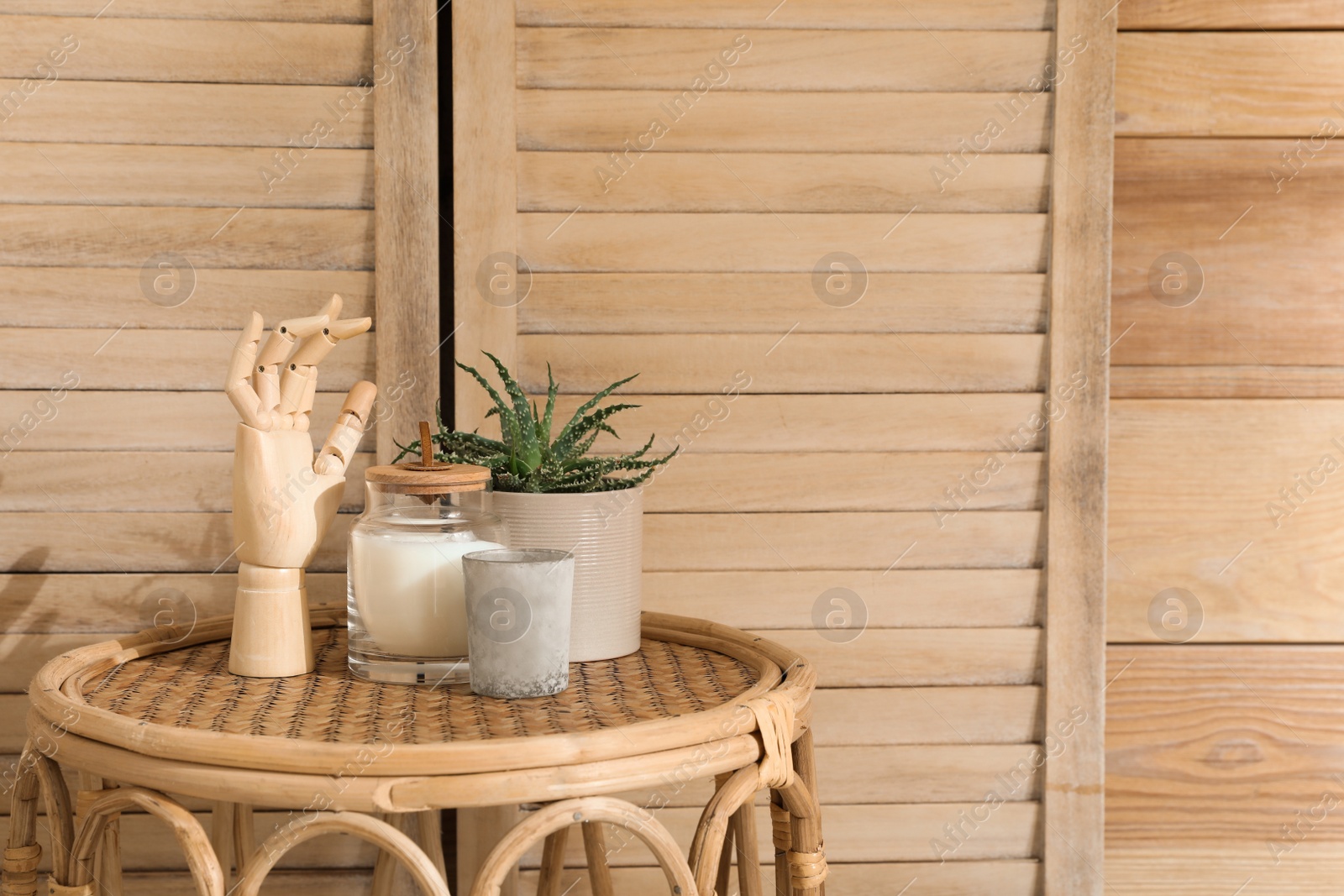 Photo of Stylish table with decor and houseplant near wooden wall, space for text. Interior design