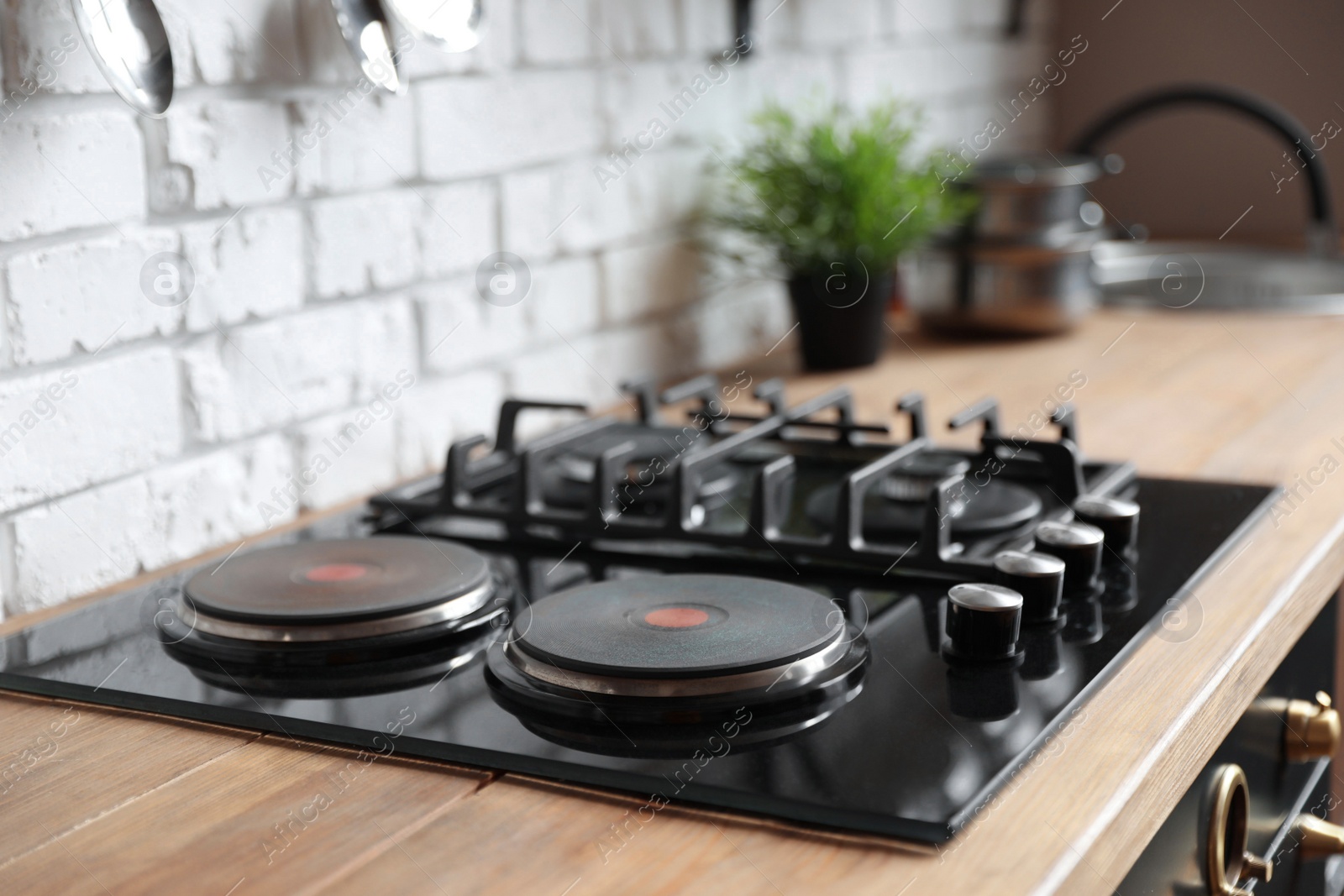 Photo of New modern stove with gas and electric burners in kitchen