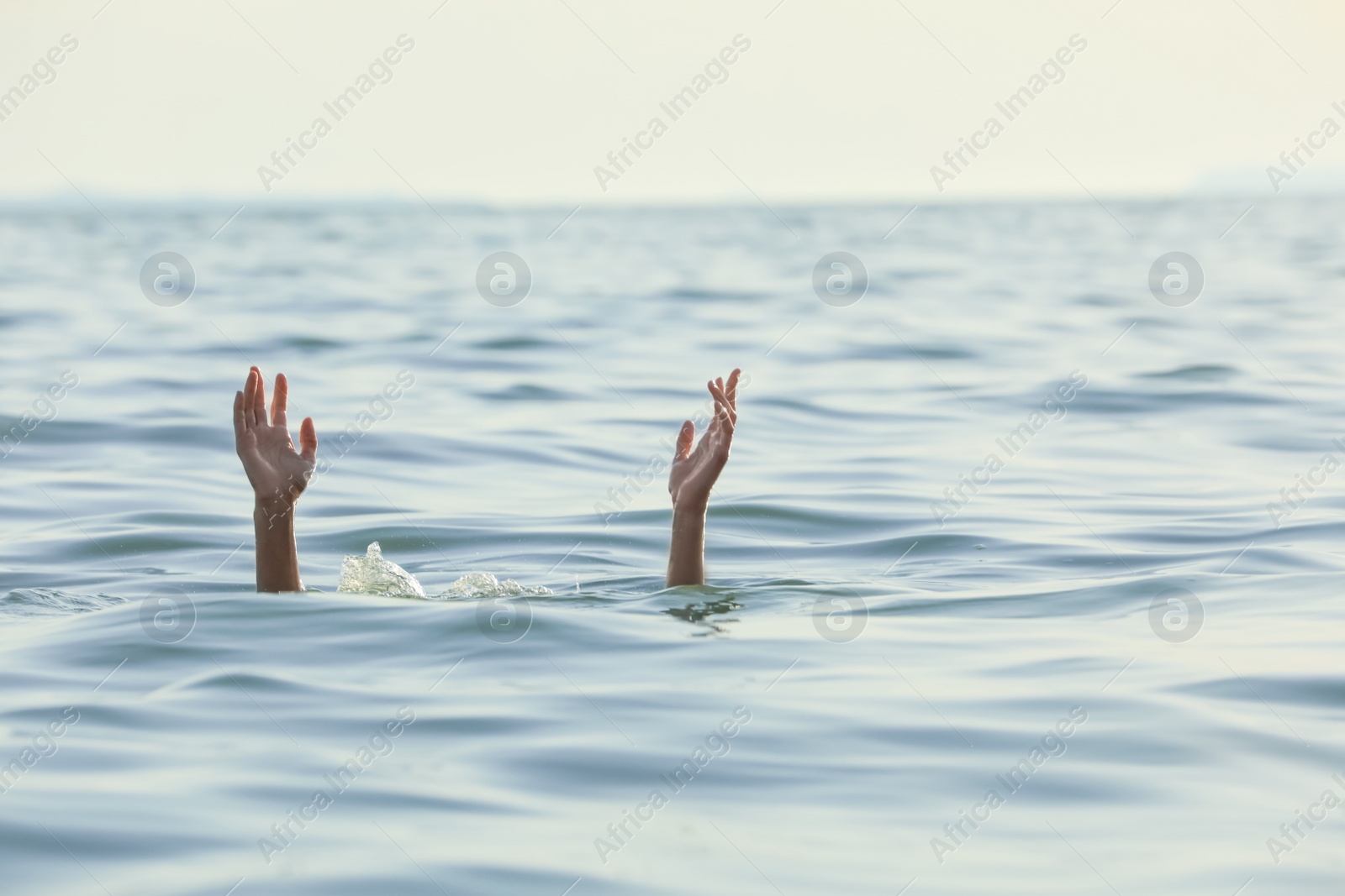 Photo of Drowning woman reaching for help in sea