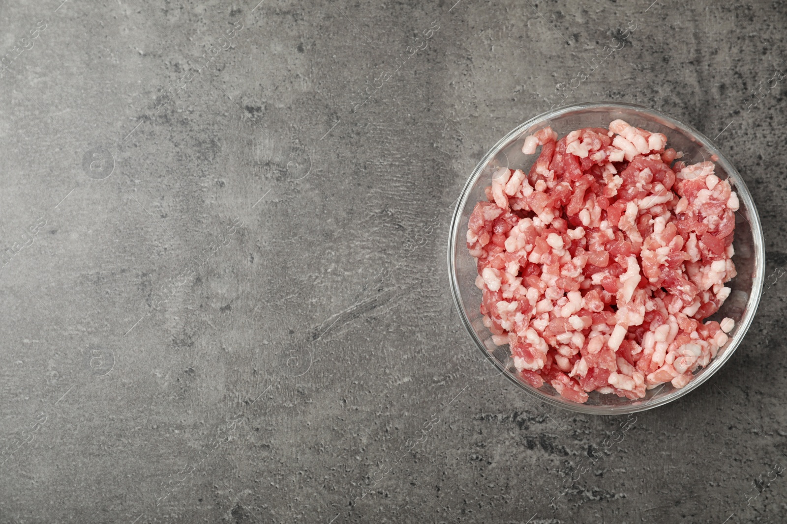 Photo of Bowl with minced meat and space for text on grey background, top view