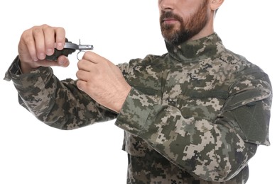 Soldier pulling safety pin out of hand grenade on white background, closeup. Military service