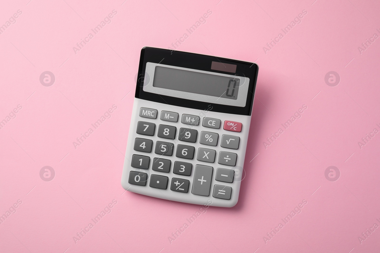 Photo of Calculator on pink background, top view. Office equipment