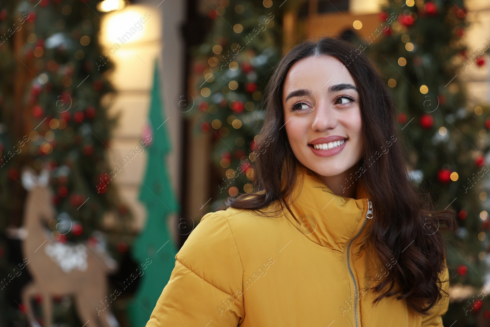 Photo of Portrait of smiling woman on city street in winter. Space for text