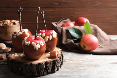 Photo of Delicious caramel apples on wooden serving board