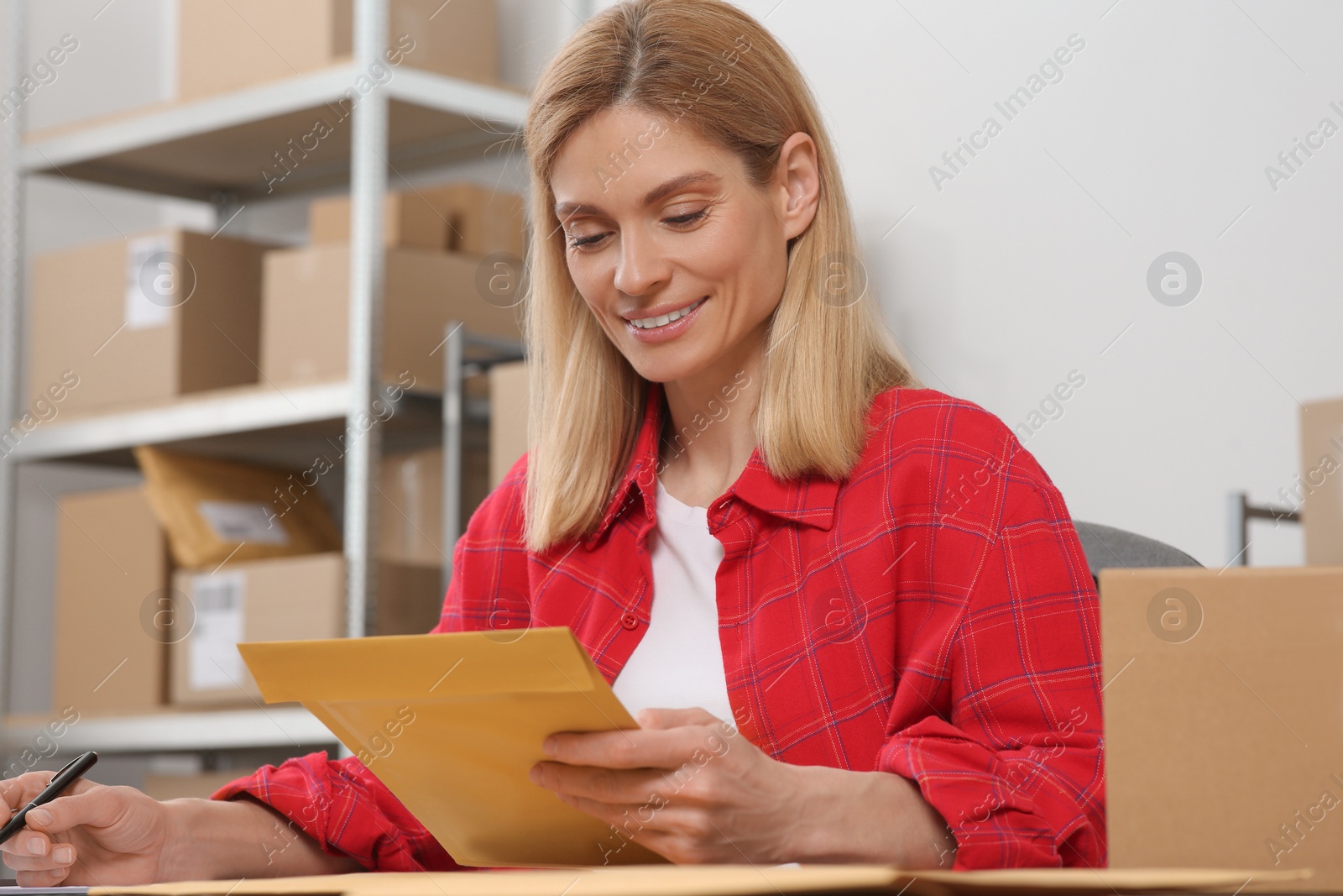 Photo of Seller with parcels working in office. Online store