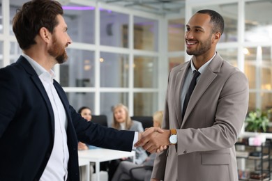 Photo of Lawyer shaking hands with client in office, selective focus