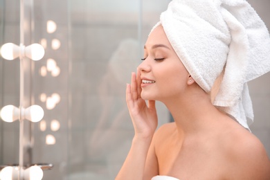 Photo of Beautiful woman with towel on head in bathroom